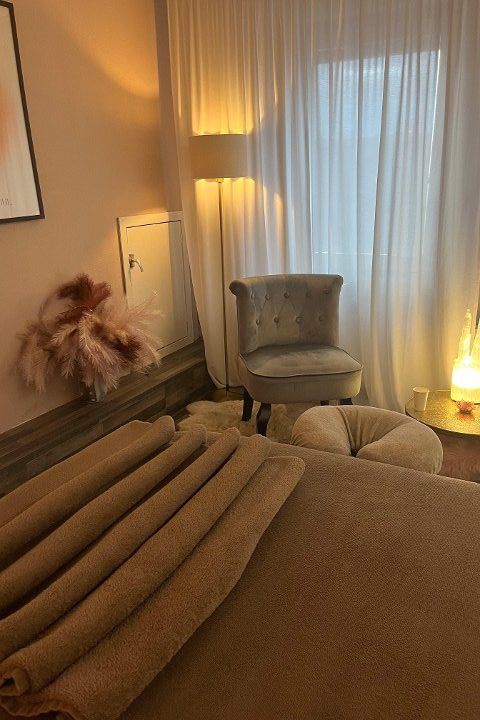 De behandelkamer van Wellness aan Zee in Egmond aan Zee met warme verlichting en opgestapelde handdoeken